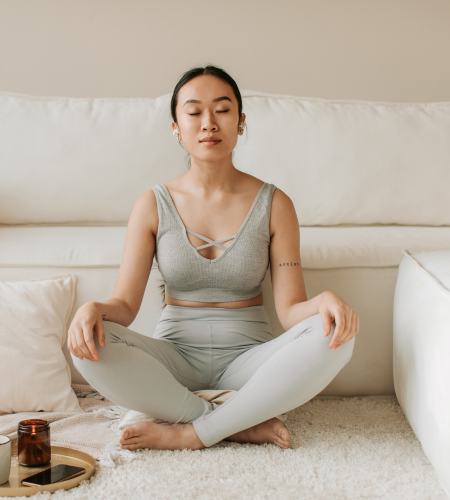 Image of woman meditating on a couch