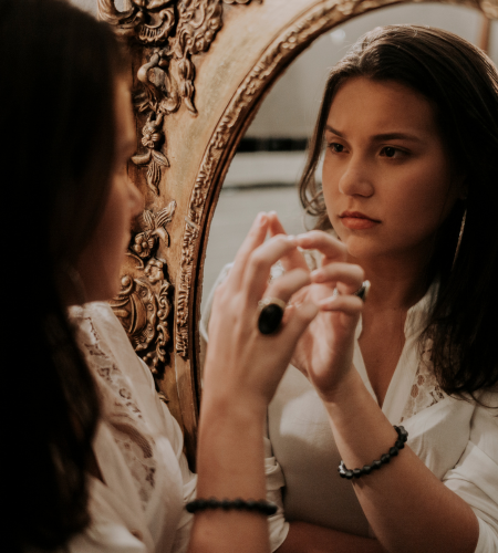 Image of woman looking at her reflection in the mirror